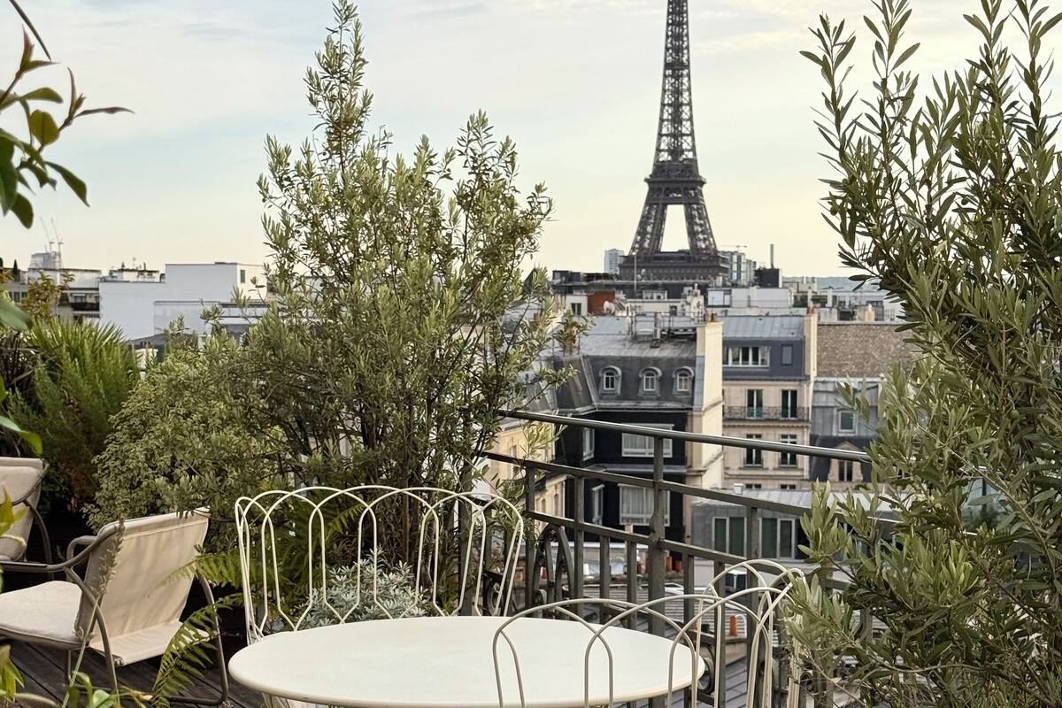 Un área de estar al aire libre con vistas a la Torre Eiffel.