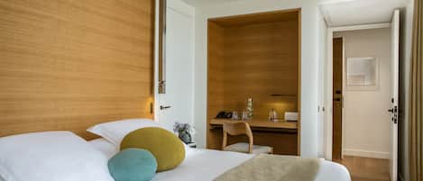 Una habitación de hotel moderna con una cama grande, un escritorio y un vestidor.