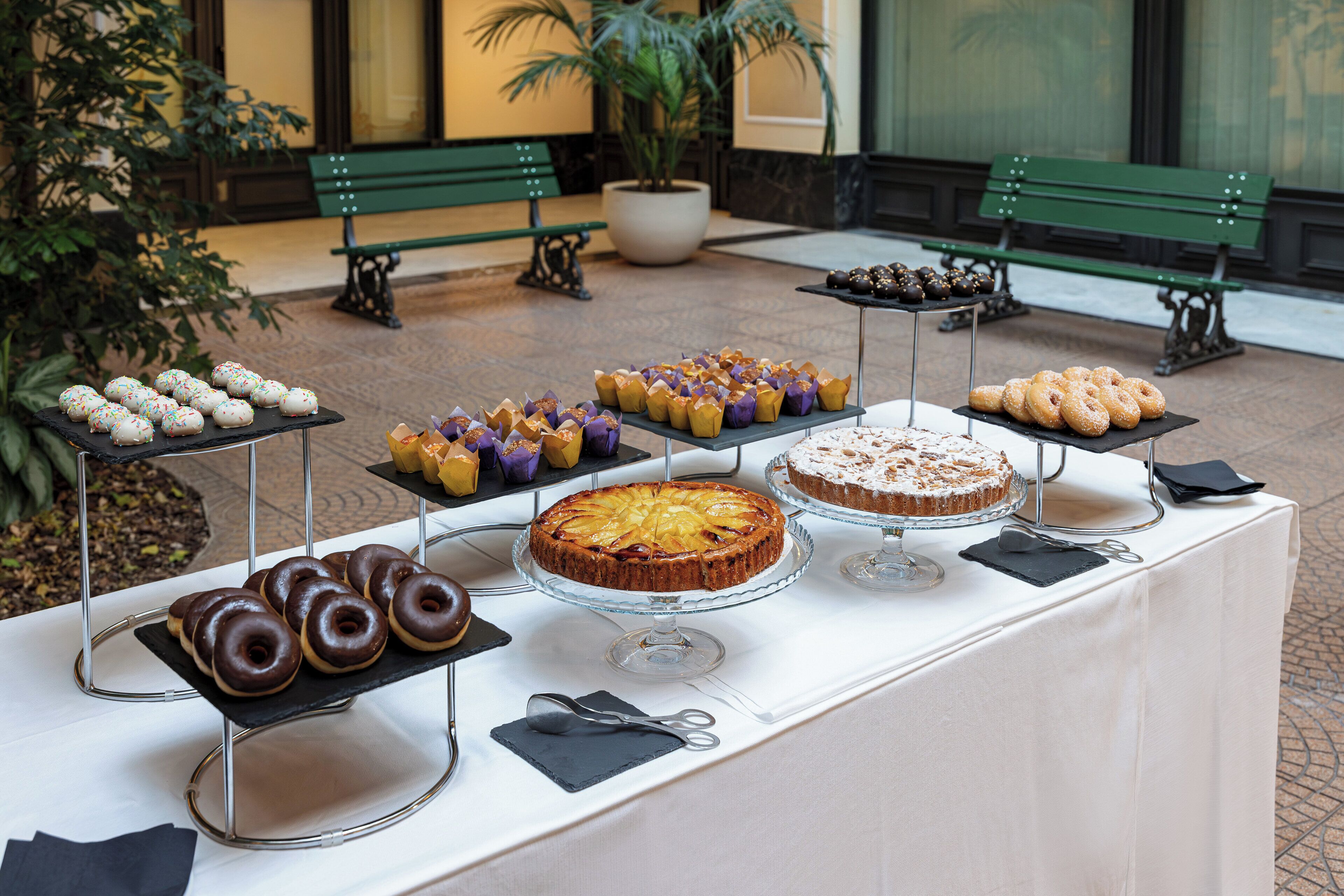 Uma mesa de buffet com diversos doces e pâtisseries.