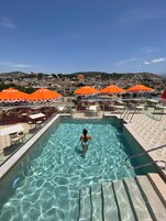 Una piscina al aire libre de temporada, sillones reclinables de piscina