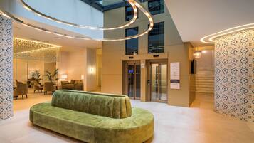 Relax in the stylish lobby, featuring a comfortable sofa and natural light pouring in from above.