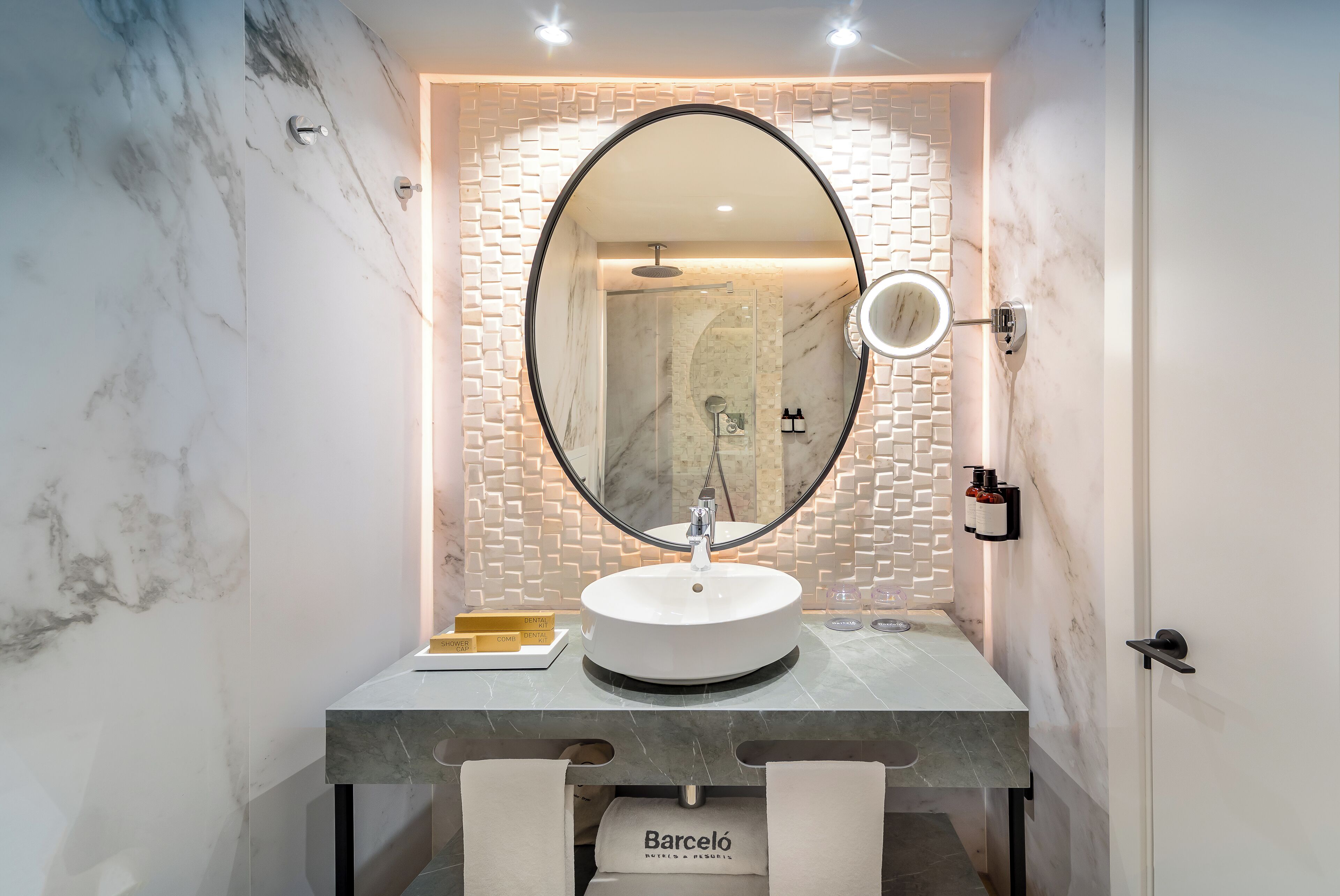 Un baño moderno con un lavamanos de mármol, un espejo grande y una pared con un diseño de ladrillo original.