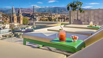 Enjoy breathtaking views of the historic church and surrounding mountains from this rooftop retreat, complete with comfortable seating and a refreshing drink station.