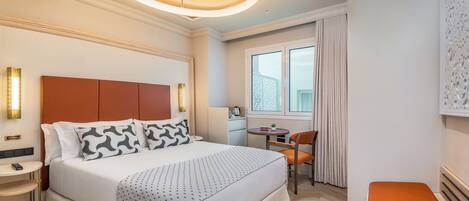 Una habitación de hotel moderna con una cama grande, un escritorio y una silla.