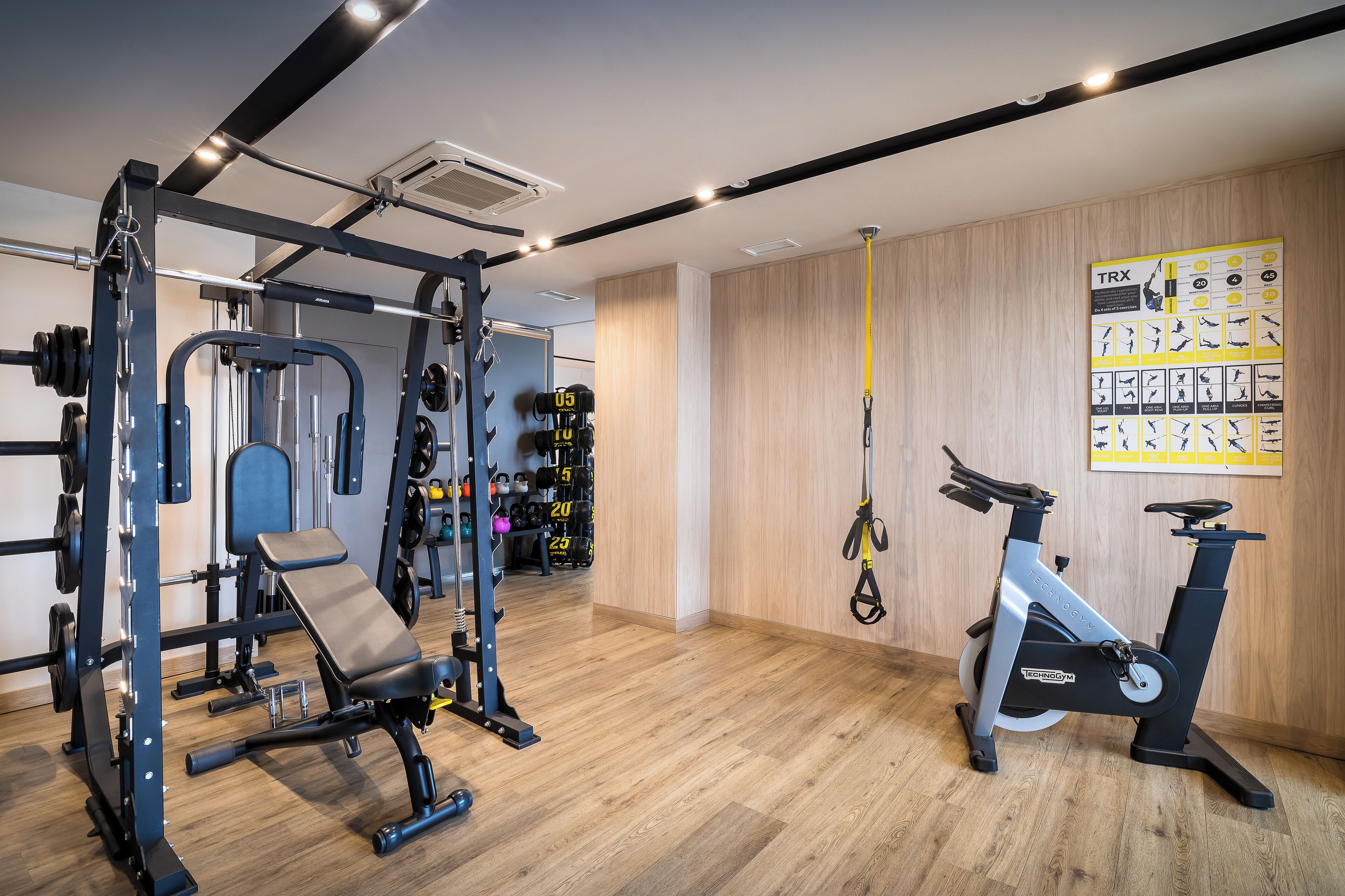 A gym with weightlifting equipment, a bench, and an exercise bike.