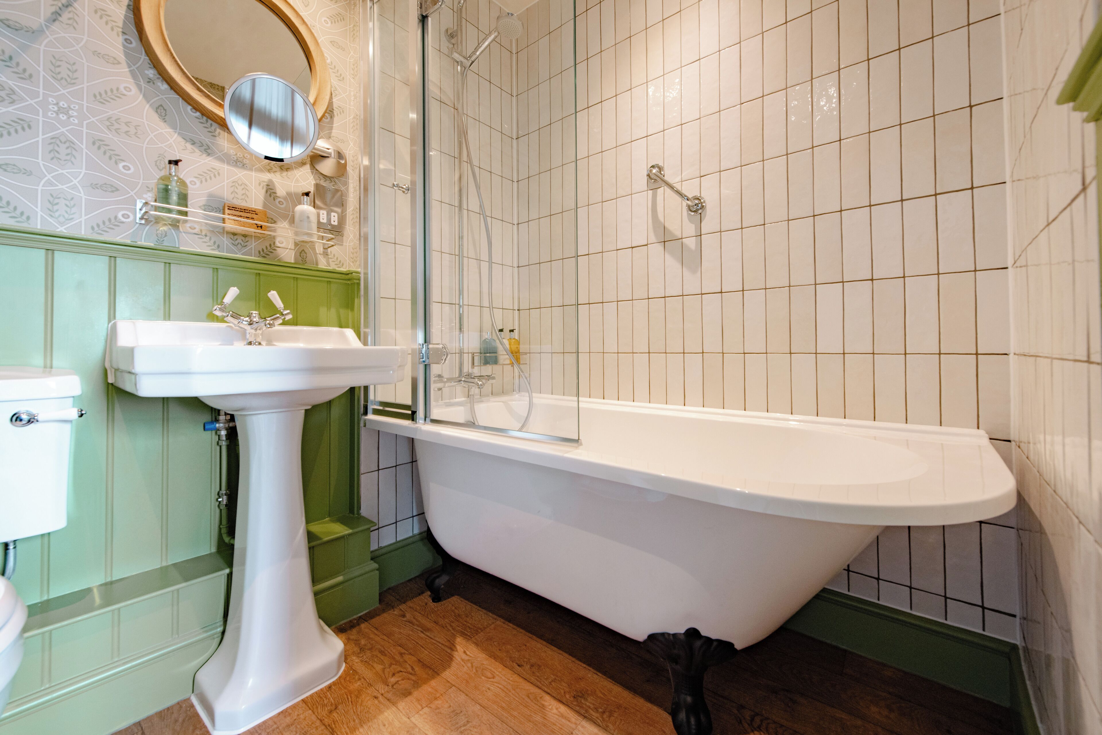 A bathroom with a freestanding bathtub, a pedestal sink, and a toilet.