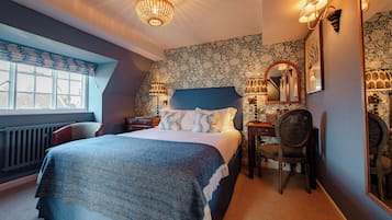 Une chambre avec un grand lit, une chaise, un bureau et une fenêtre.