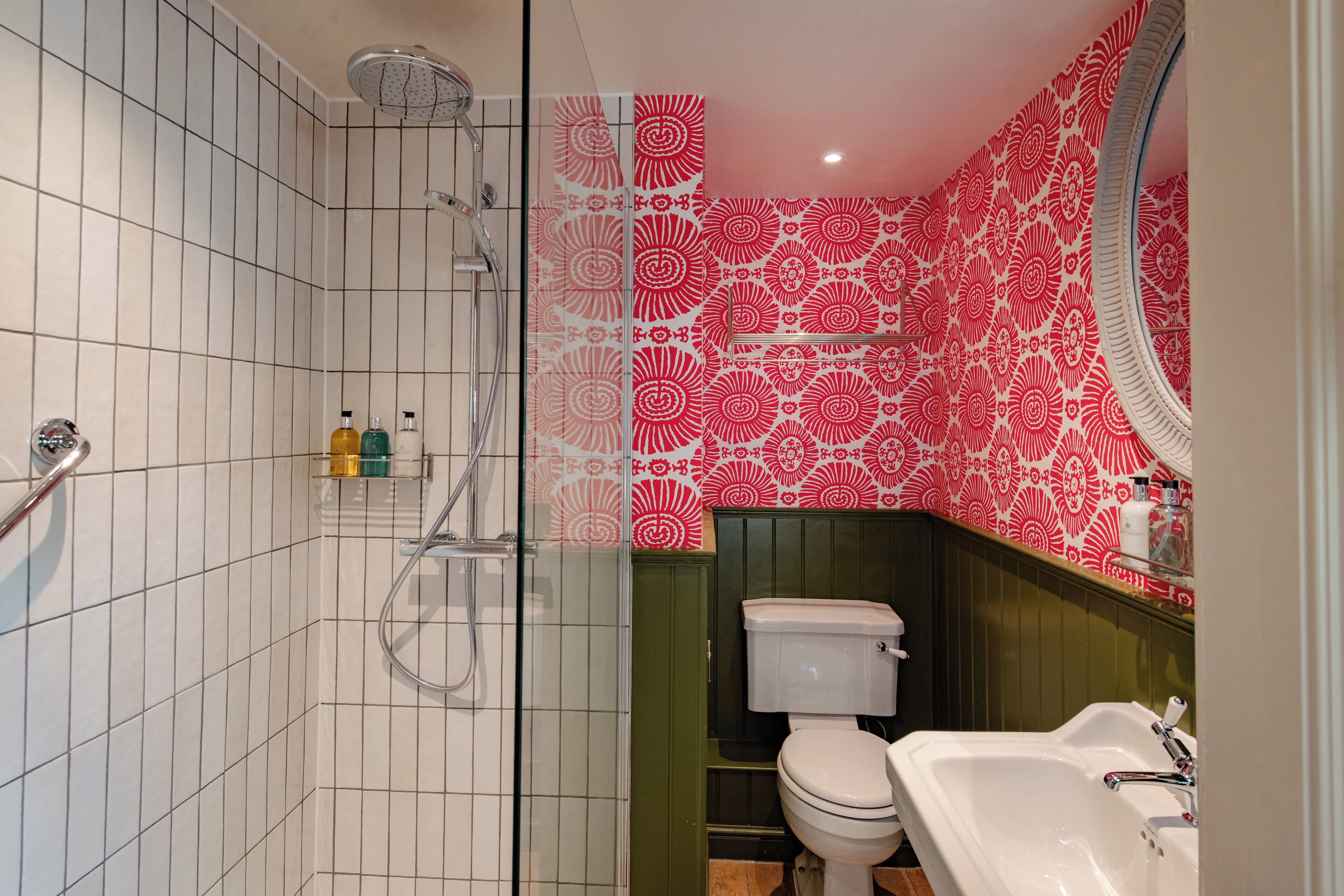 Een badkamer met douche, toilet en wastafel.