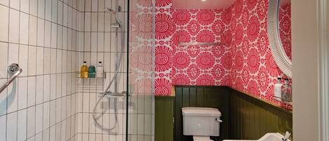 A bathroom with a shower, toilet, and sink.