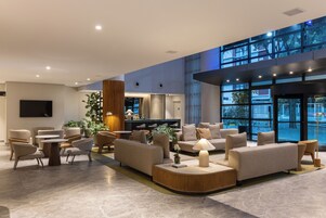 Una hall moderna con divani, tavoli e un'area bar.
