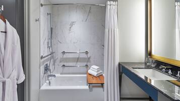 Une salle de bain moderne équipée d’une douche, d’une baignoire, d’un meuble-lavabo avec un miroir et d’un porte-serviettes.