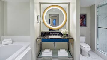 Une salle de bain moderne avec une baignoire, un meuble-lavabo avec un miroir, des toilettes et une douche en verre.