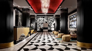 A luxurious lobby with a checkered floor, a chandelier, and black and gold decor. - Grand Bohemian Orlando, Autograph Collection (Orlando)