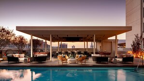 A rooftop pool area with seating and a covered patio. - Grand Bohemian Orlando, Autograph Collection (Orlando)