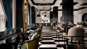 A modern interior with a black and white patterned floor, a bar area, and a seating area with sofas and chairs. - Hotel Beauden, Autograph Collection (Orlando)