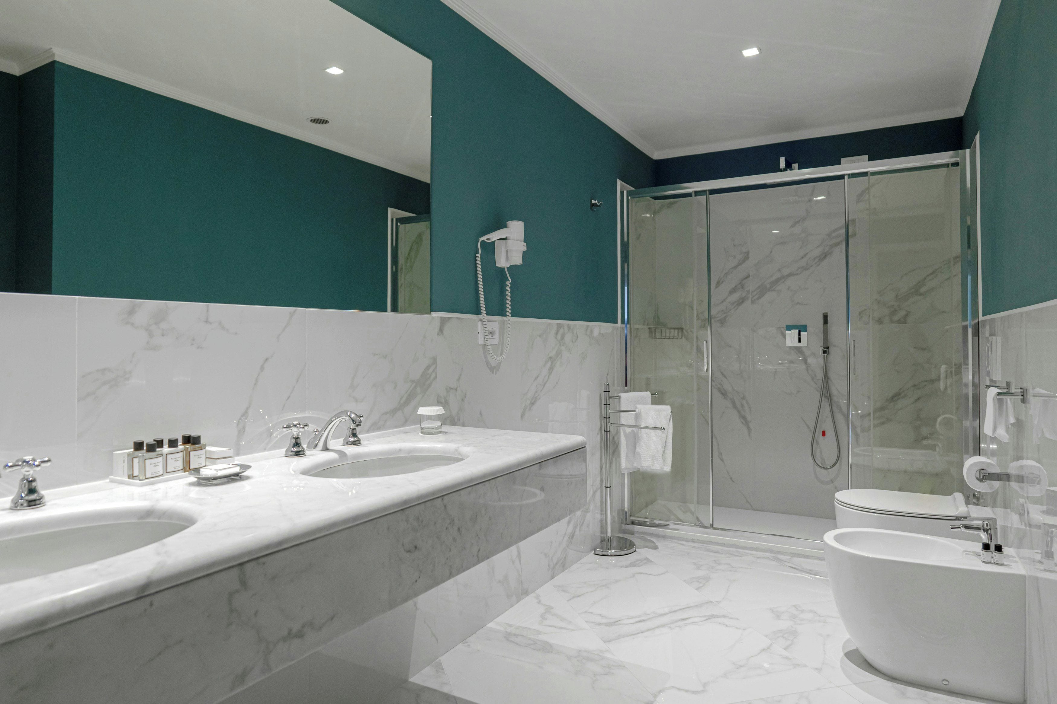 Un bagno moderno con due lavandini, una doccia e un water.