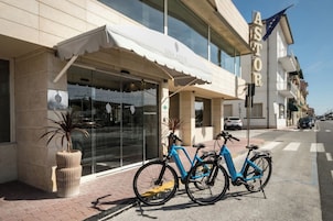 Un edificio con escaparate que dice 'SINA ASTOR' y una bicicleta azul estacionada afuera.