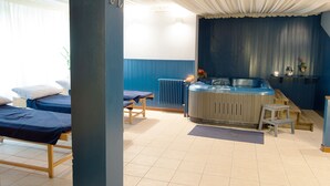 Una habitación con dos camas, una mesa de masaje, una sauna y un radiador.