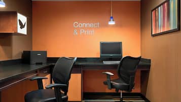 A modern office space with two black office chairs, a desk with a computer, and a 'Connect & Print' sign on the wall.