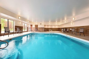 Relax by the pool surrounded by lounge chairs and tables.