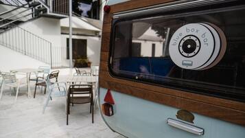 Una furgoneta camper antigua con un panel lateral de madera y un adhesivo en la ventana que dice "blue box bar".