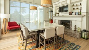 Una cocina moderna con una isla grande, armarios blancos y una chimenea.