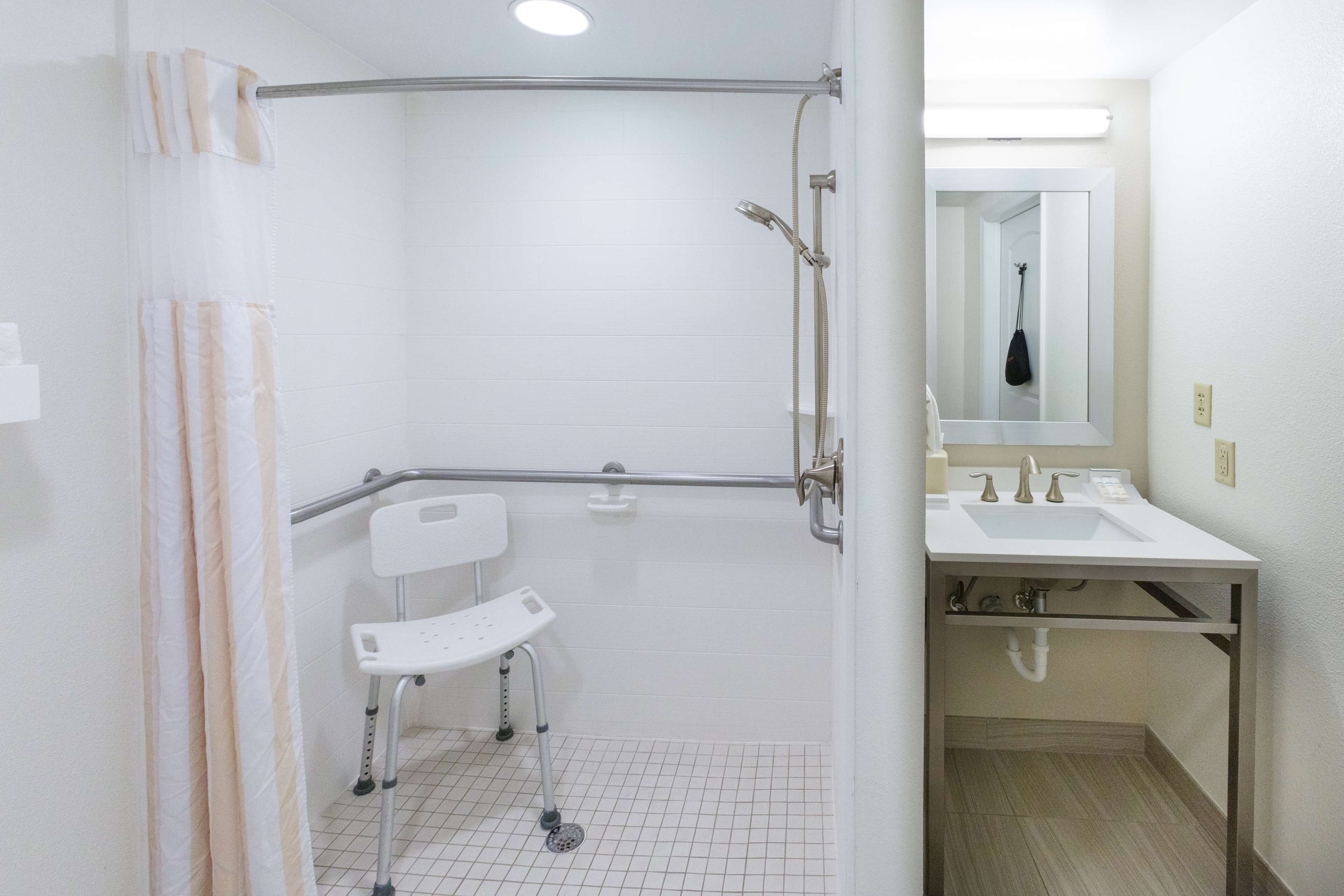 A bathroom with a shower, a toilet, and a sink.