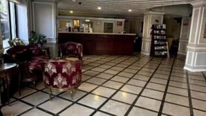 A spacious lobby with a checkered floor, a reception desk, and seating areas. - Albatros Premier Hotel - Special Class (Istanbul)