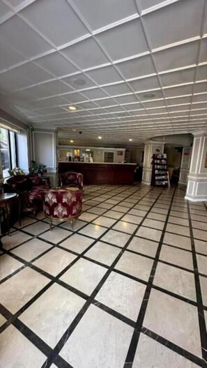 A spacious lobby with a checkered floor, a reception desk, and seating areas. - Albatros Premier Hotel - Special Class (Istanbul)