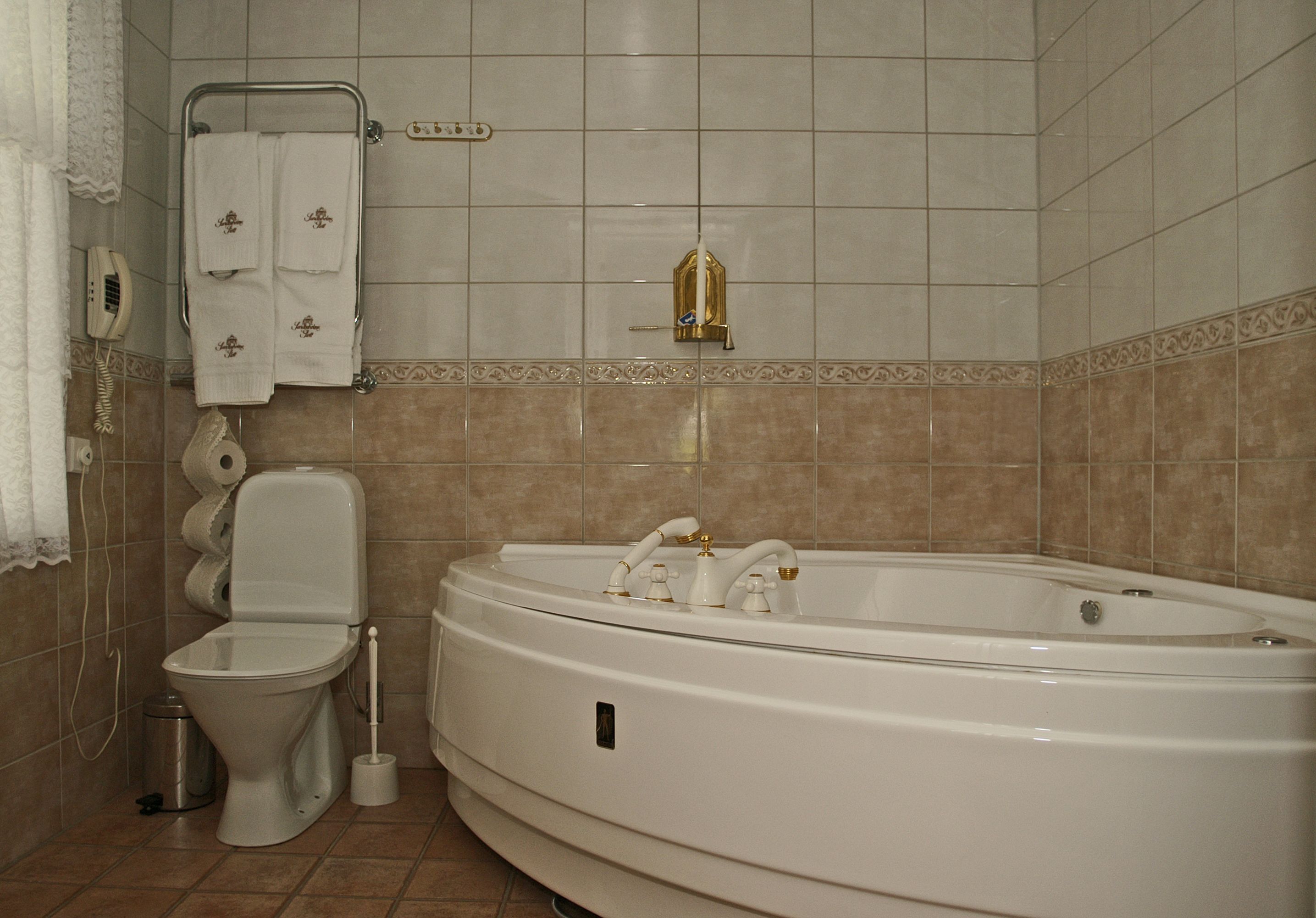 A bathroom with a toilet, a bidet, a bathtub, and a towel rack.