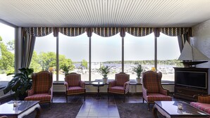 Una sala de estar con un ventanal grande, dos sillones, una mesa de centro y un televisor.