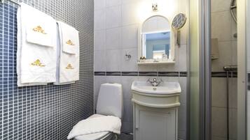 Un baño con inodoro, lavabo y ducha.