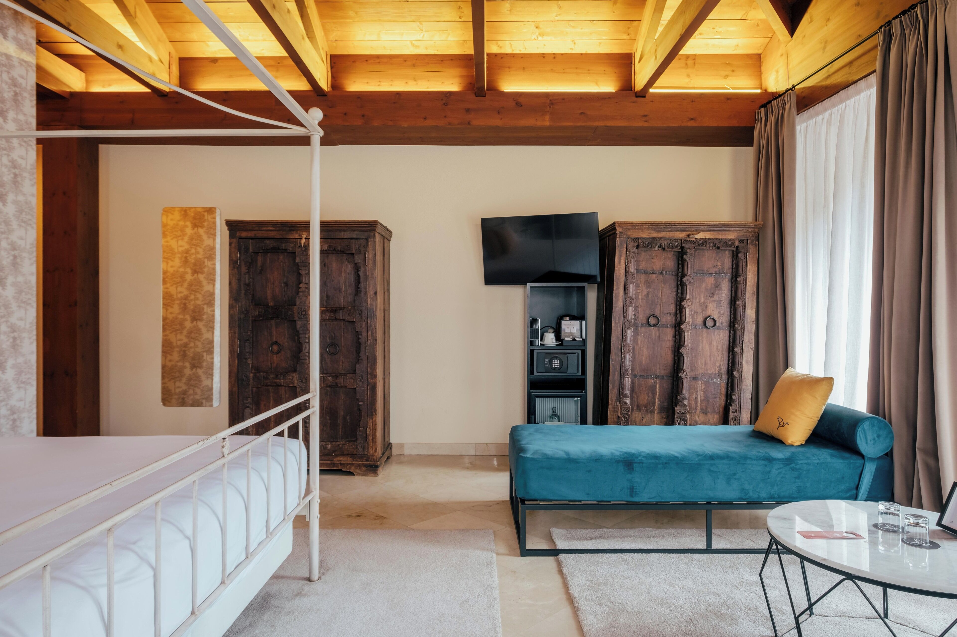 A room with a bunk bed, a sofa, a TV, and wooden cabinets.