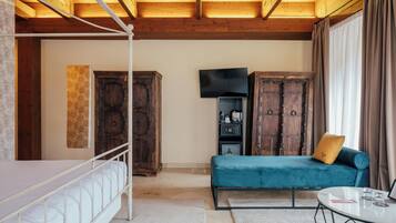 A room with a bunk bed, a sofa, a TV, and wooden cabinets.