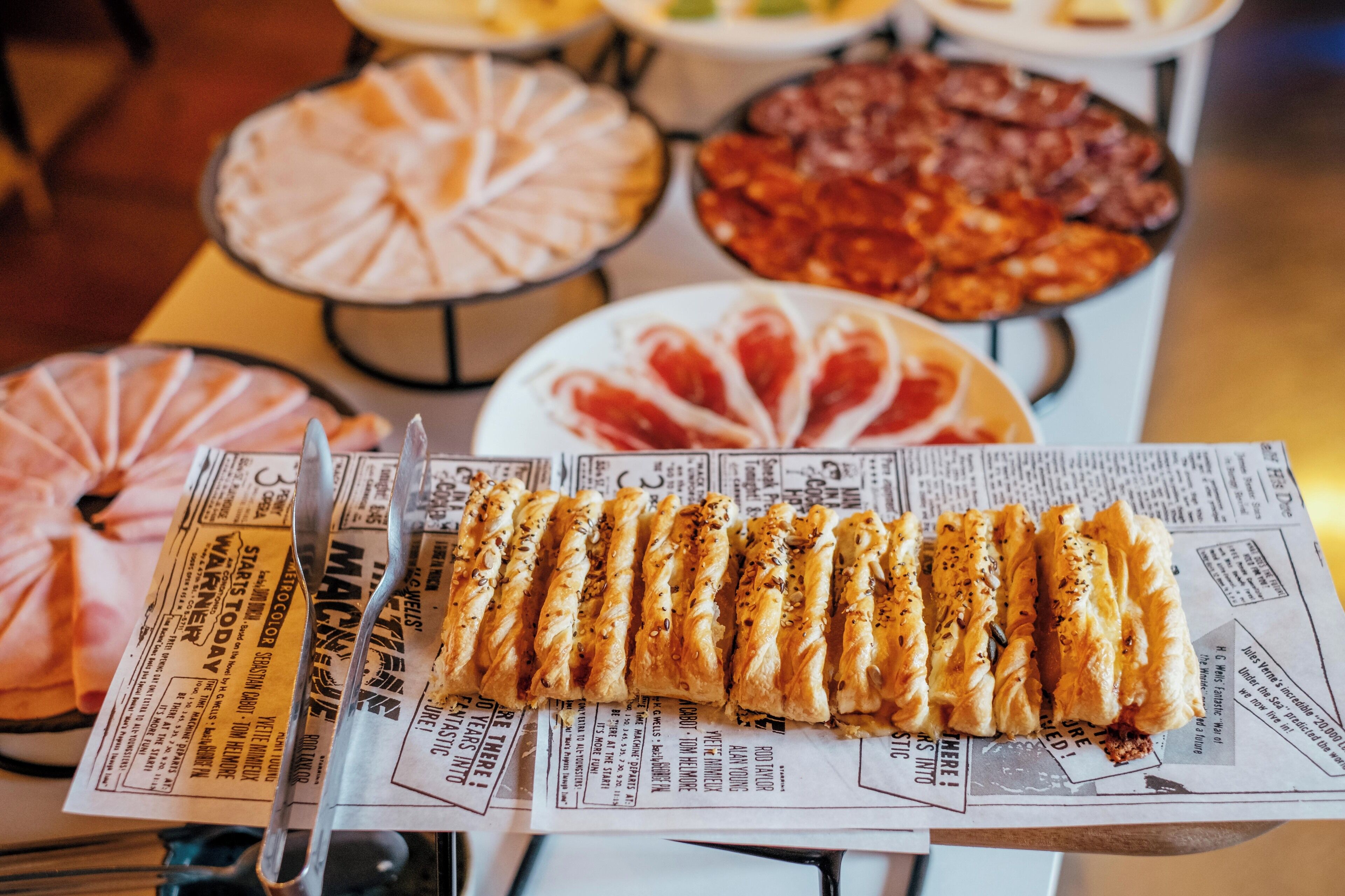 A buffet table with various dishes including a selection of pastries, salads, and meats.