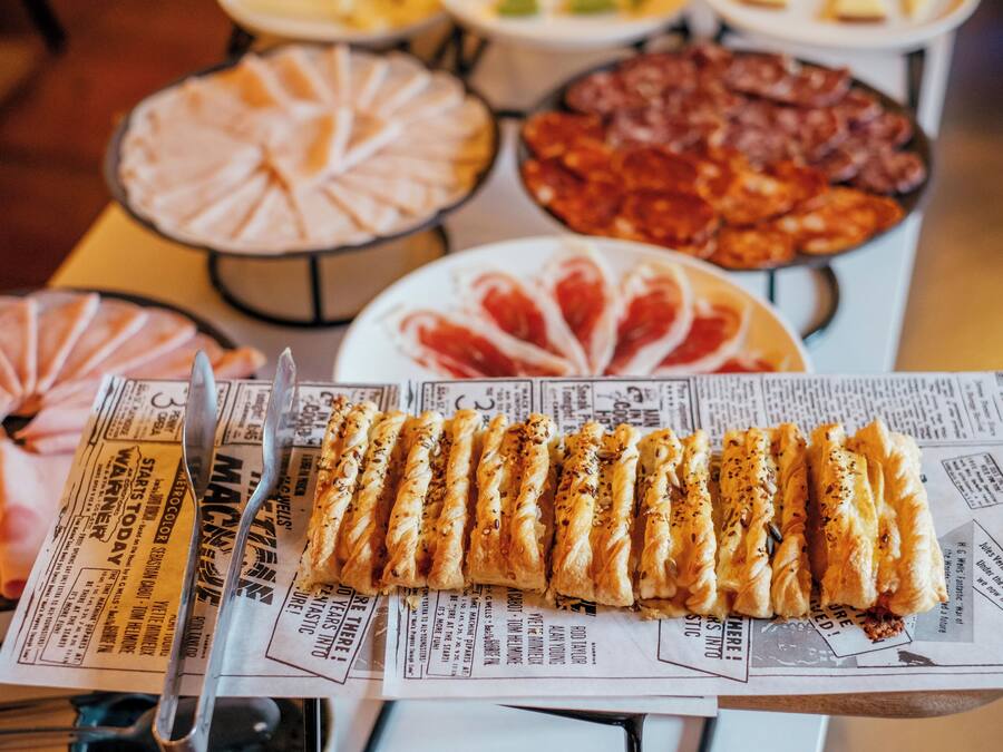 A buffet table with various dishes including a selection of pastries, salads, and meats.
