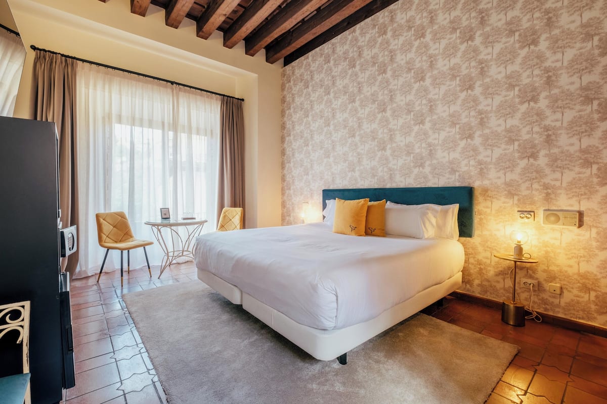 Ein Hotelzimmer mit einem großen Bett, einem Schreibtisch und einem Stuhl.