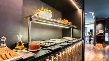 Uma mesa de buffet com diversos alimentos e acompanhamentos.
