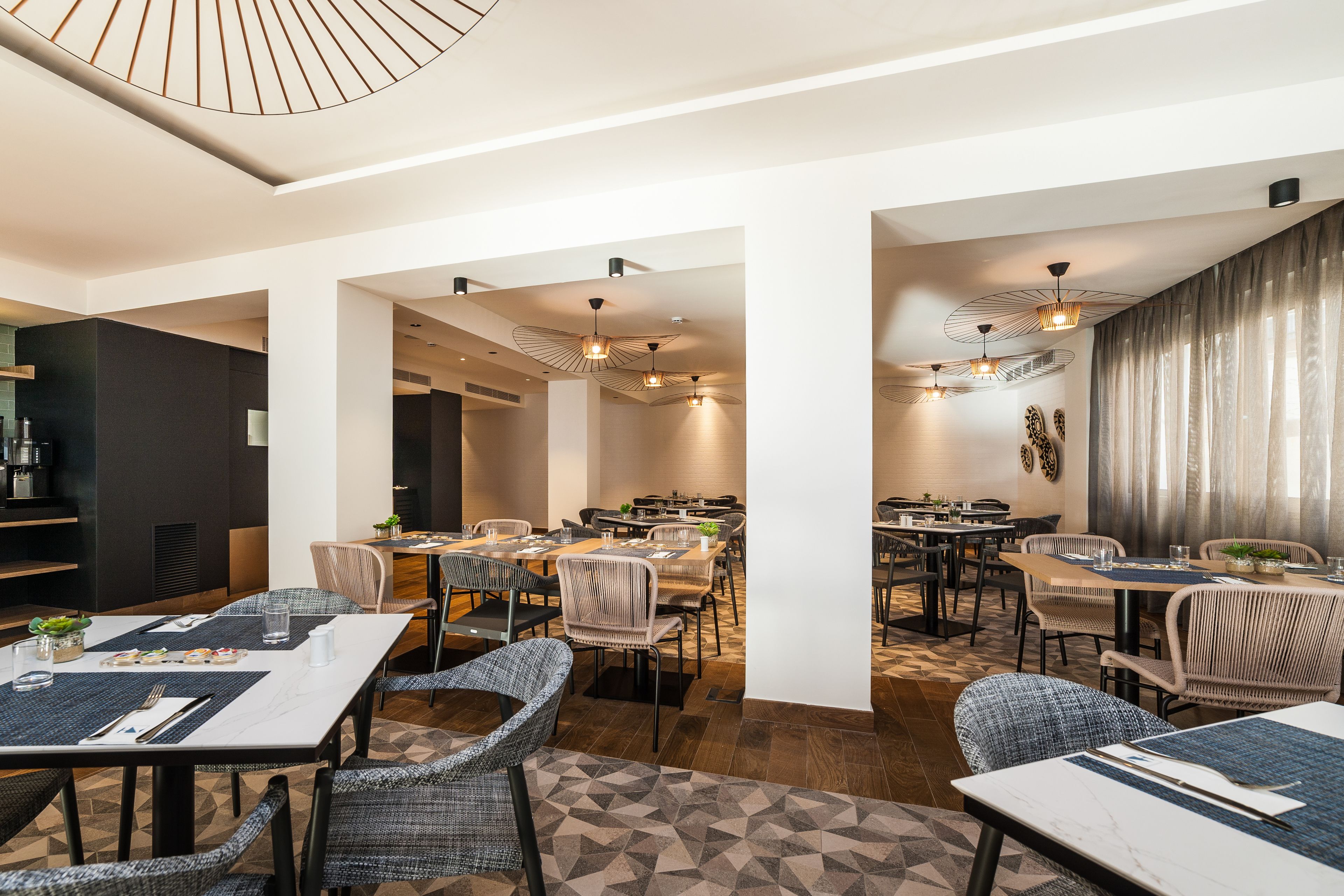 A modern restaurant with high tables and chairs, ambient lighting, and a clean, open layout.