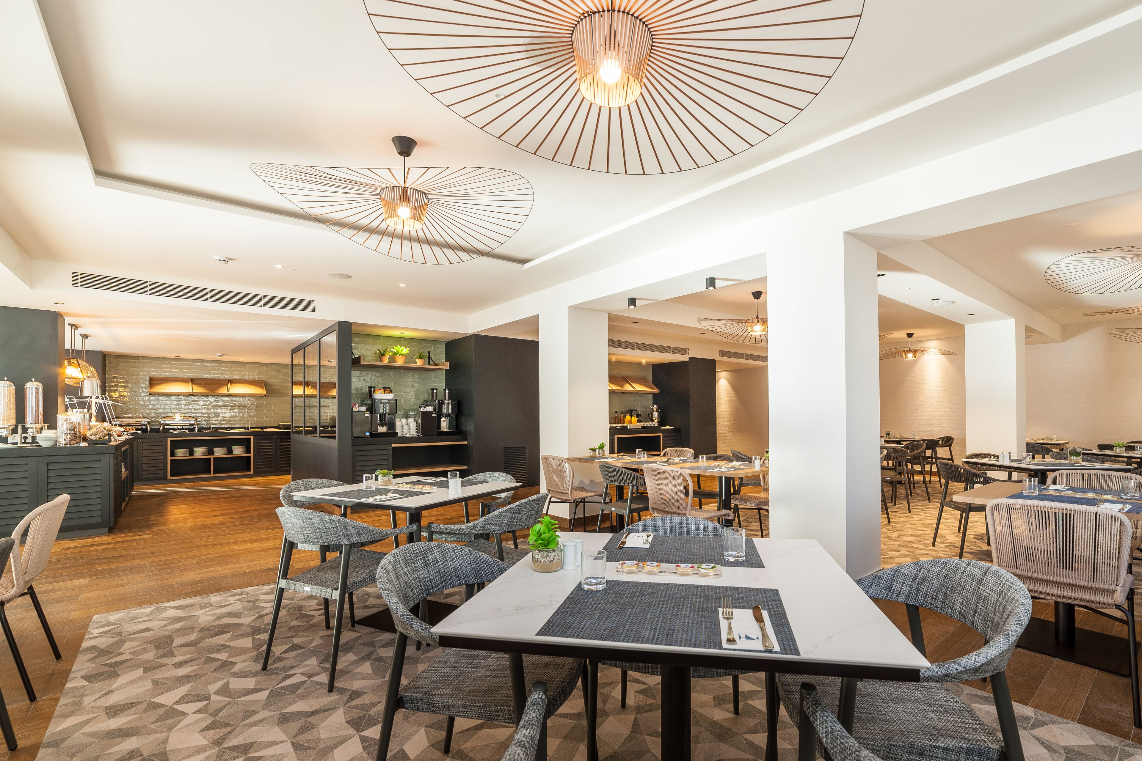 Un comedor moderno con una mesa central, sillas alrededor e iluminación colgante.