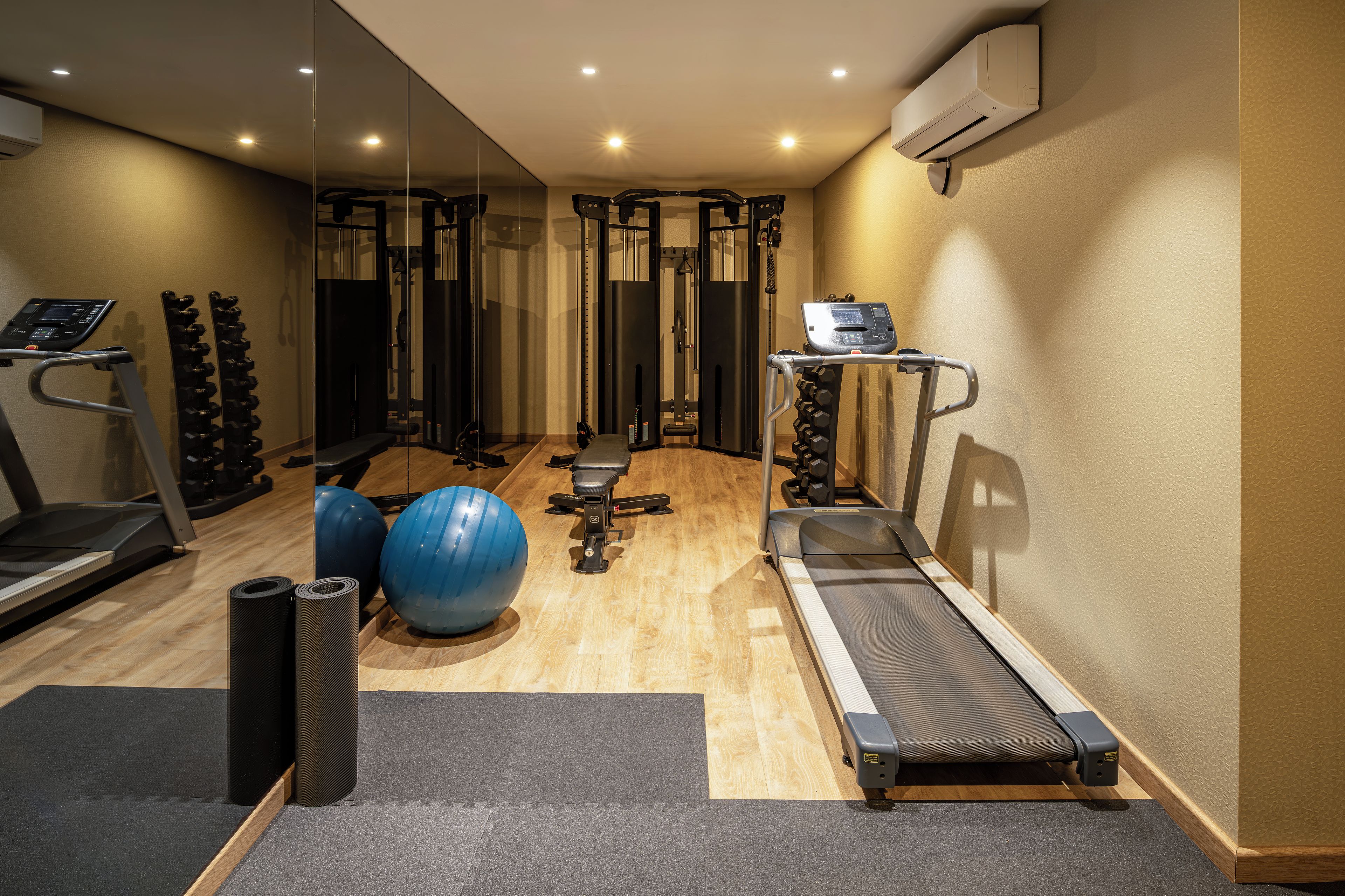 A gym with treadmills, exercise balls, and weight machines.