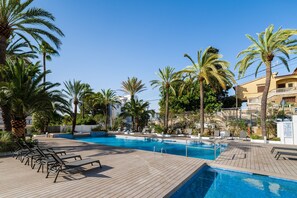 A pool area with lounge chairs and palm trees. - Eurostars Marivent Hotel (Palma de Mallorca)