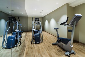 A fitness room with cardio machines, including treadmills and an elliptical, on a wooden floor. - Eurostars Marivent Hotel (Palma de Mallorca)