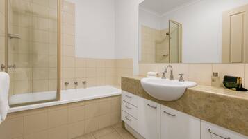 A modern bathroom with a bathtub, a sink, and a large mirror.