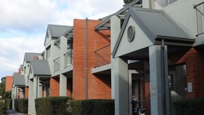 A row of modern buildings with a uniform architectural style, featuring balconies and large windows. - Quest Bendigo (Golden Square)
