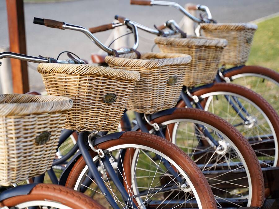 Uma fileira de bicicletas com cestas de vime e pneus marrons.