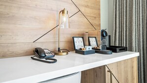 A hotel reception desk with a telephone, a desk lamp, a speaker, and framed certificates.
