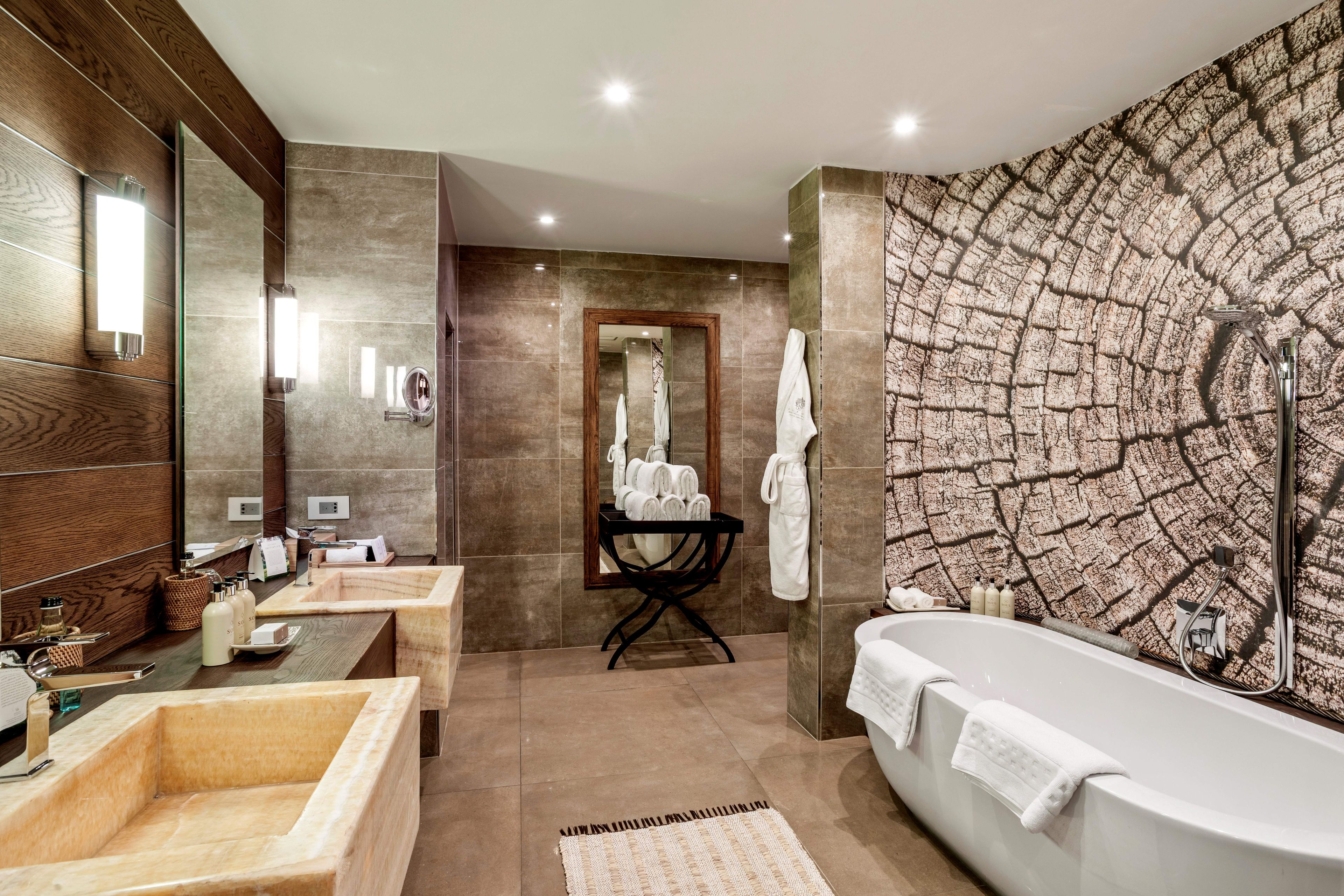 Une salle de bain moderne avec une baignoire sur pieds, un meuble-lavabo avec un miroir et un grand miroir fixé au mur.