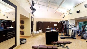 A gym with exercise equipment, a mirror, and a reception desk.