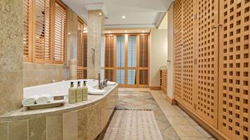 A modern bathroom with a curved sink, a large mirror, and wooden sliding doors.